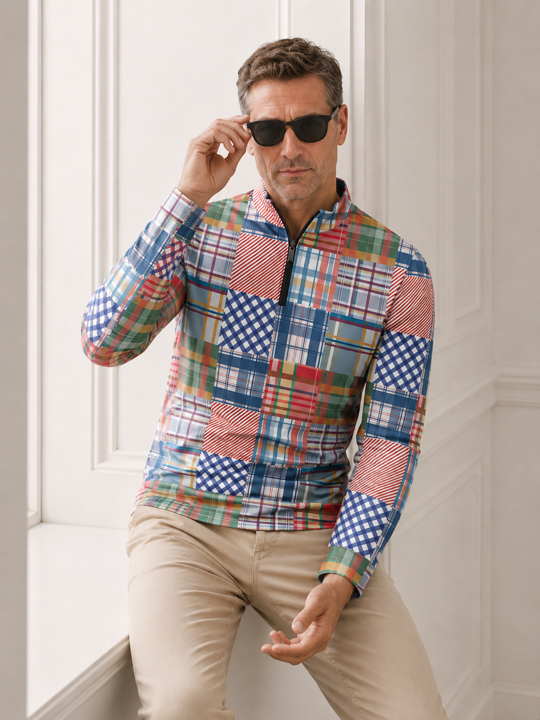Man wearing a colorful multi-patterned long-sleeve performance golf shirt and khaki pants.