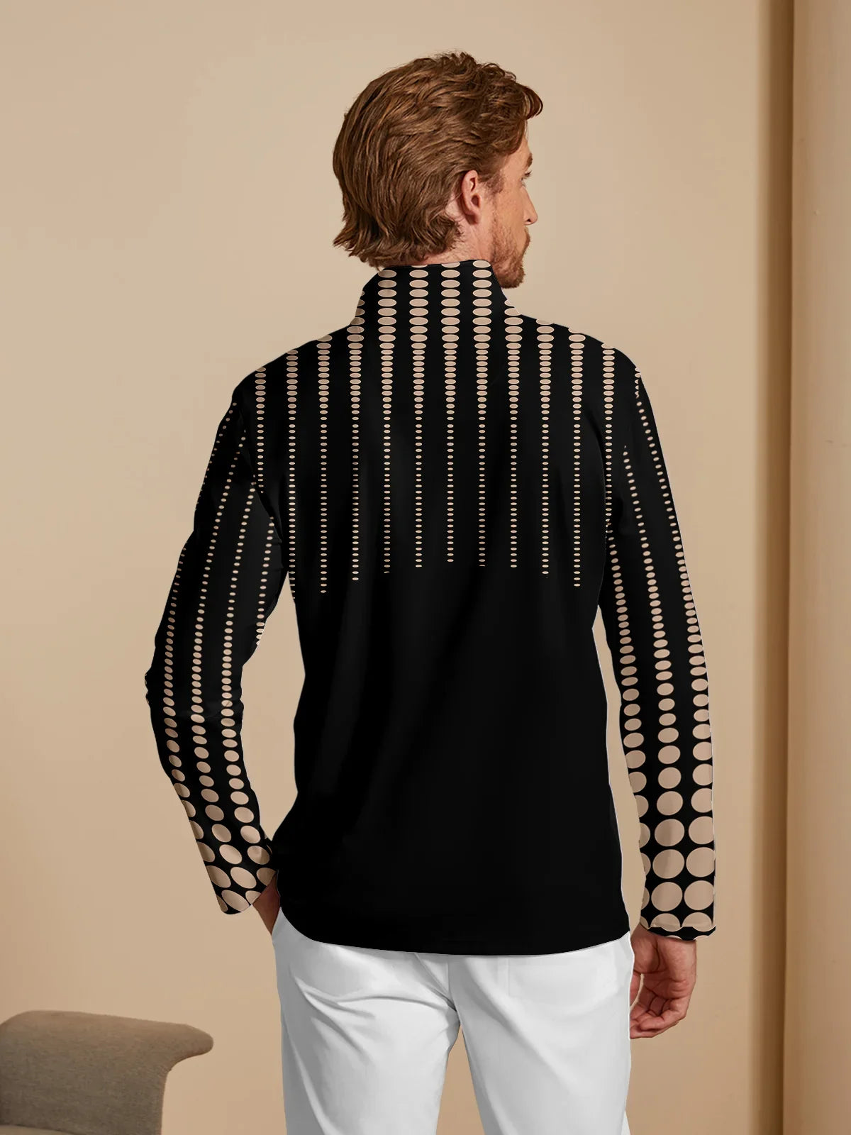 Rear view of a man wearing a black long-sleeve performance golf shirt with a tan dot print.