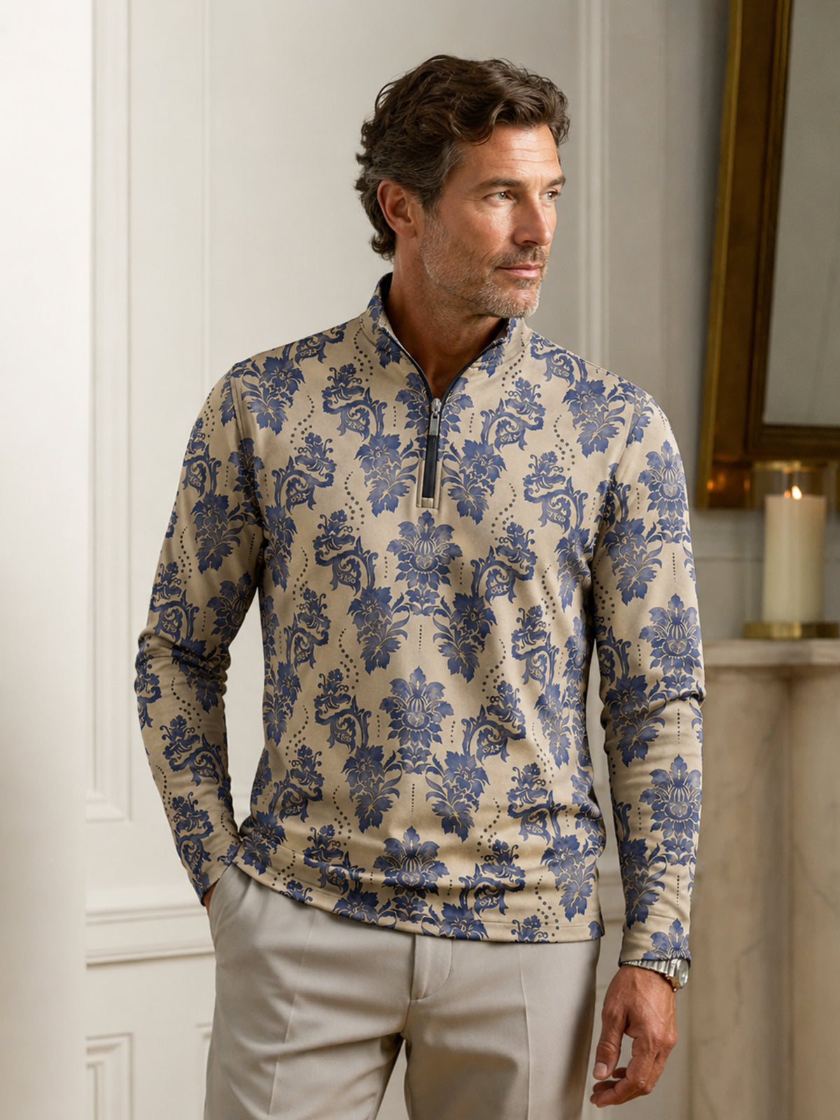 Man wearing a blue and beige damask print performance quarter-zip golf shirt and beige pants.