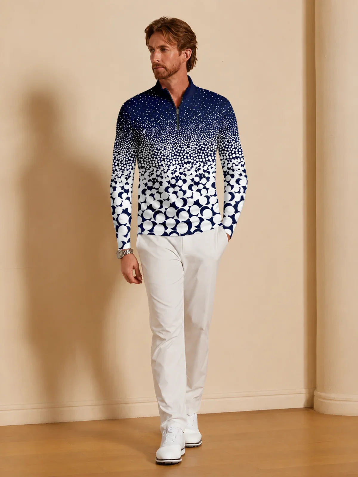 Man wearing a blue and white patterned quarter-zip golf pullover and white golf pants.
