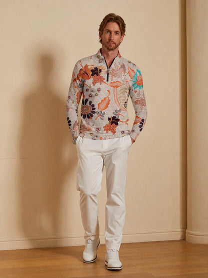 Man wearing a floral print quarter-zip performance golf shirt and white golf pants.