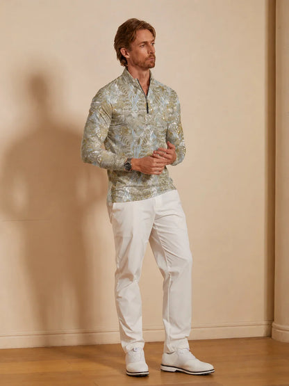 Man wearing a patterned quarter-zip performance golf shirt and white golf pants.